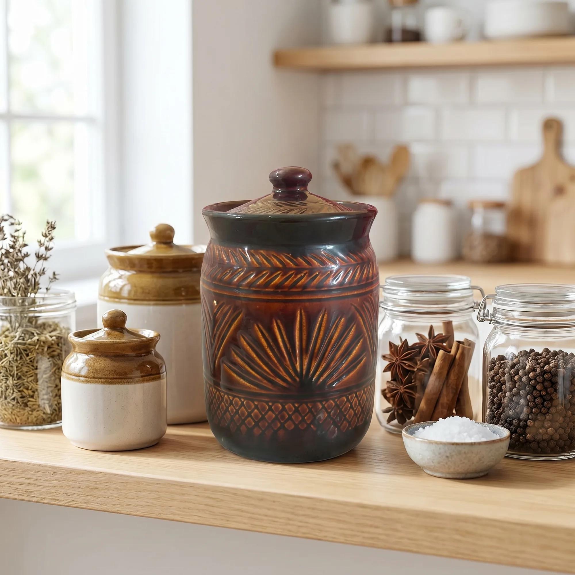 Multiple ceramic jars and glass spice jars arranged on a light wooden countertop.