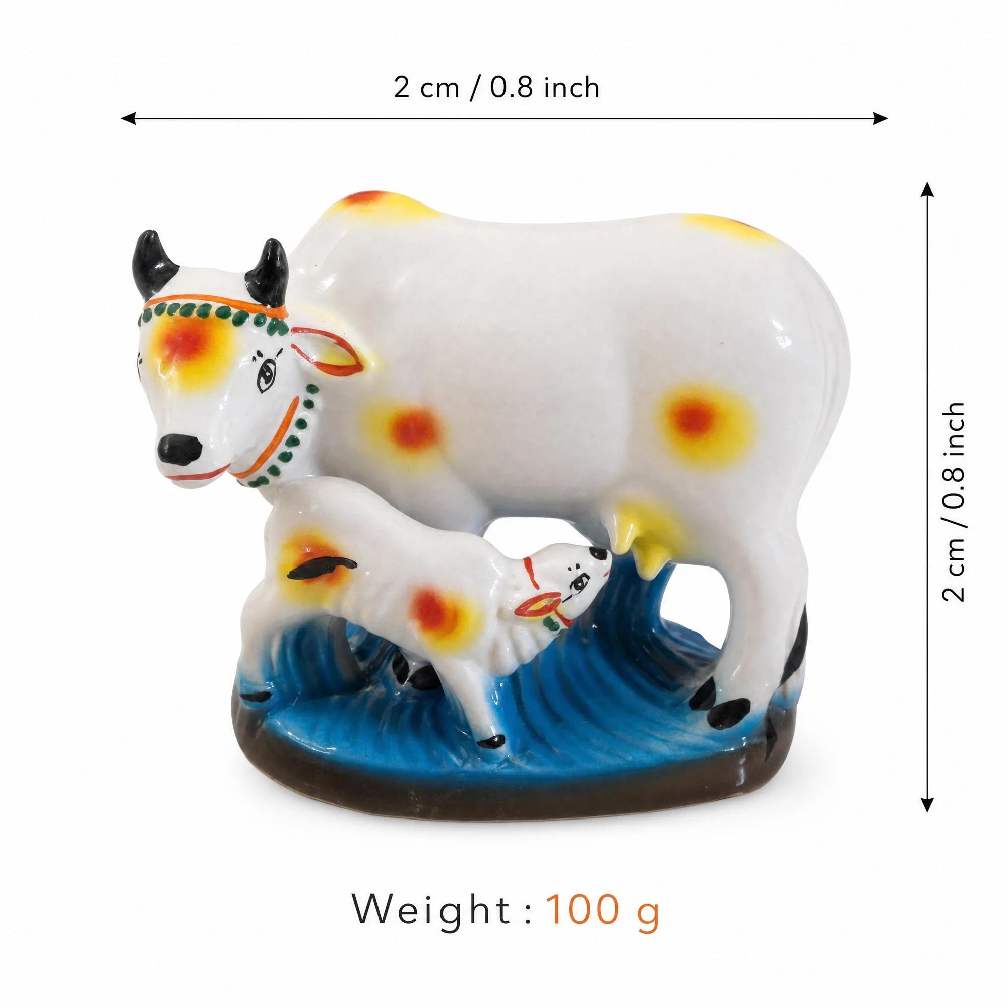 White ceramic Kamadhenu cow and calf showpiece with overlaid measurements (2 cm / 0.8 inch height/width) and weight (100g).