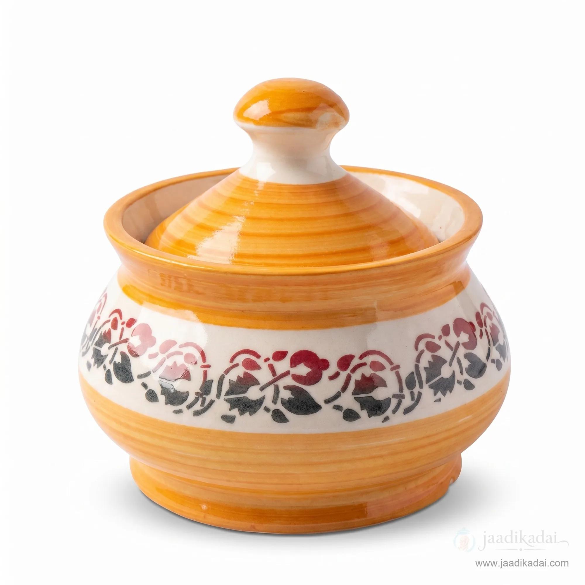 Front view of the round orange and white ceramic storage pot with lid on a white background.