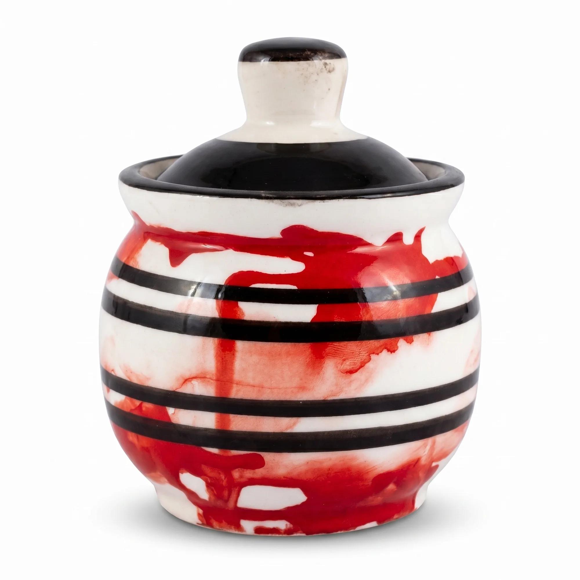 Front view of the 100ml red and black stripe ceramic storage jar with its lid, isolated on a white background.